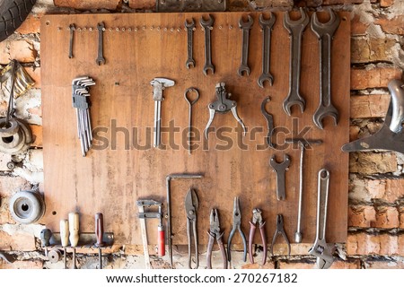 Old vintage tools hanging on a wooden clipboard, hobby time in garage.