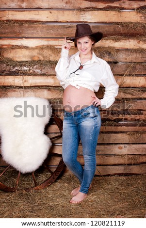 The beautiful pregnant woman in a cowboy\'s hat