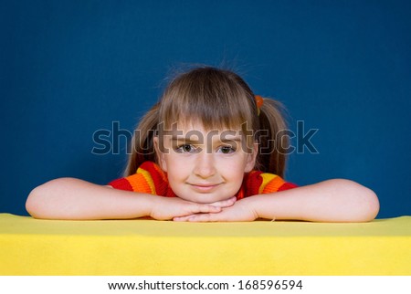 Smiling girl (6 years) on a yellow blanket