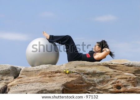 Woman uses her pilates ball for an abs workout.