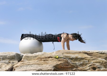 Woman performs a pilate exercises with a fitness ball