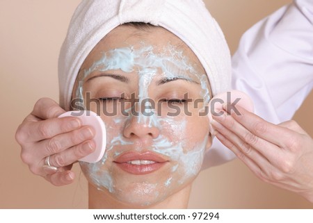 Beauty therapist cleansing womans face