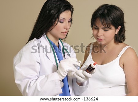 A doctor or nurse consults with a young pregnant woman