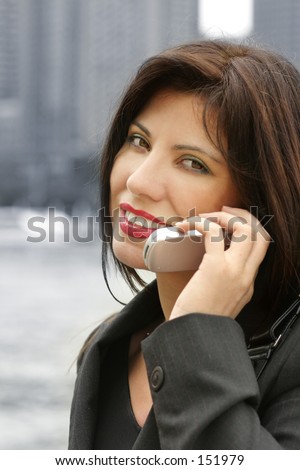 Business communications - woman against a blue backdrop of buildings.