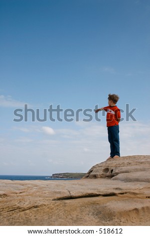 Boy Looking and pointing yonder way At the isolated rocks of Mistral Point East Sydney. Focus on the boy
