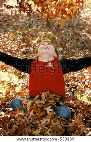 Autumn Joy:  A boy throws a pile of leaves overhead and watches them fall. 400iso