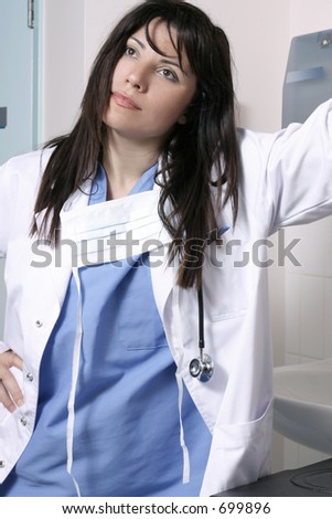 Doctor in scrubs uniform and white overcoat in hospital