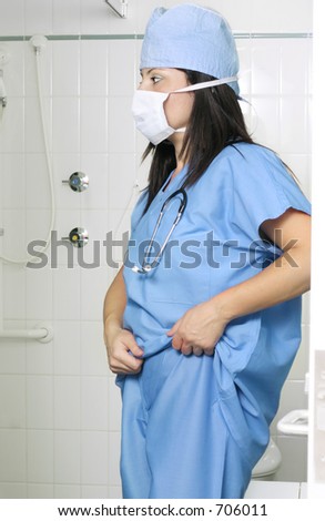 Surgeon putting on scrubs uniform