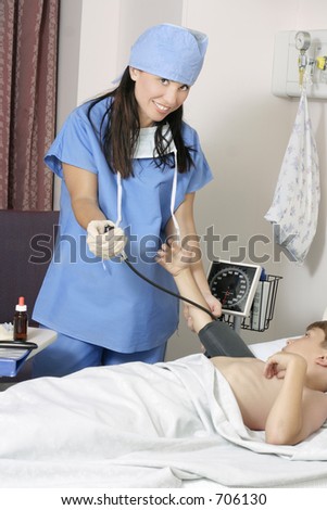 A hospital worker measures a patient's blood pressure.