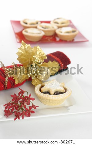 Sweet fruit mince pies.   Red Australian Christmas bush decorative napkin.  Focus on foreground.