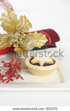 Fruit mince pie on a plate adorned with Australian Christmas bush and napkin.