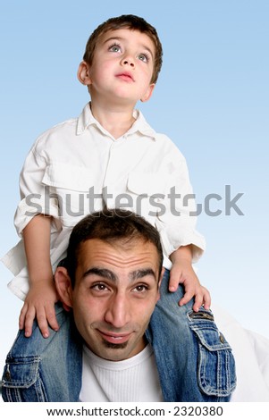 Sky is the limit....   A child sits atop his father\'s shoulders looking skyward.