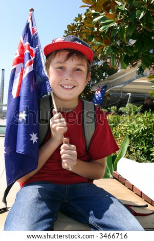 Young patriotic smiling boy holding an Australian flag on a beautiful summer day