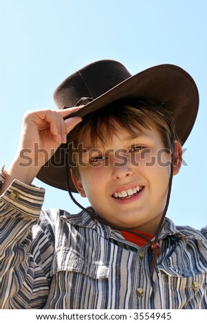 A country boy wearing brown hat and shirt, with a warm friendly smile.