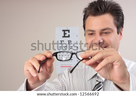 An optometrist examining a pair of eyeglasses frames.