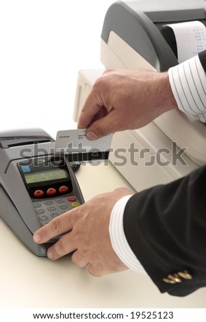 A salesman retailer swipes a credit or debit card through a pos terminal.  Focus to terminal and card.  Details removed from card.