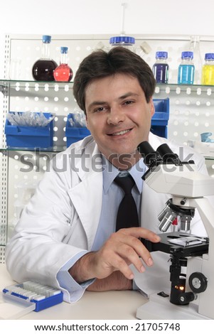 Smiling Scientific researcher sitting at laboratory desk  using a microscope for further analysis of substances...