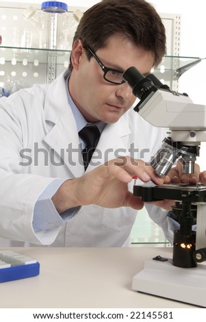 A researcher positions a slide under the microscope for study.