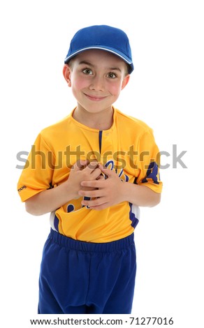 Young boy wearing a baseball or T-ball style sport outfit and blue cap.  White background.