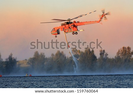 Penrith, Australia - October 23, 2013: Nsw Rural Fire Service Erickson Air-Crane Fills With Water To Fight Bush Fires In The Blue Mountains. Heavy Smoke Fills The Air.
