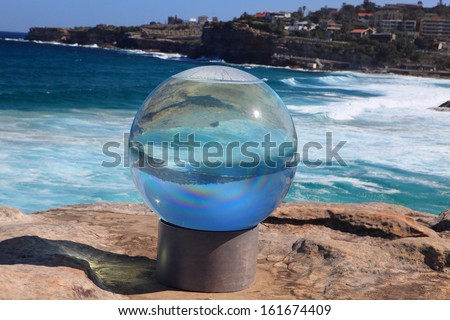 BONDI BEACH, AUSTRALIA - OCTOBER 30, 2013: Sculpture By The Sea. Annual free cultural  event  Sculpture titled \'Horizon\' by Lucy Humphrey (NSW).  Medium acrylic sphere, water, steel, timber, masonry.