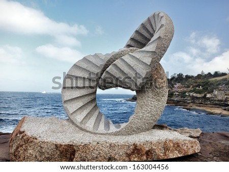 BONDI, AUSTRALIA -  OCTOBER 30, 2013: Sculpture By The Sea, Bondi 2013.  Sculpture titled \'2 rings\' by Keizo Ushio, medium, granite $115000.  Image has been toned.