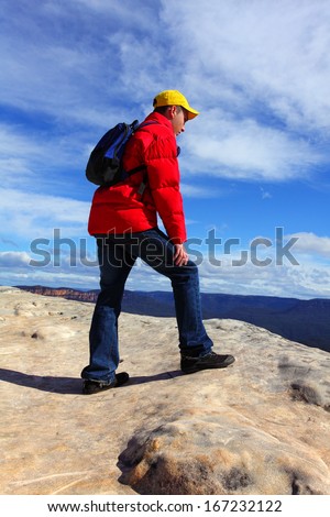 A mountain hiker, tourist or bushwalker admiring views top of mountain.