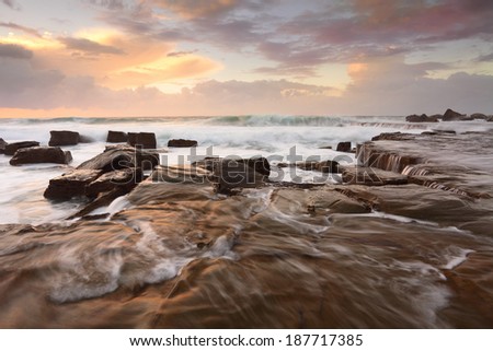 High seas, ocean waves and overflows on the rock shelf at  Forresters Beach NSW Australia