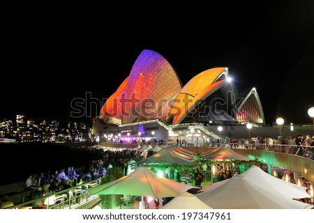 SYDNEY OPERA HOUSE, AUSTRALIA - MAY 28, 2014 -  Vibrant visual imagery and colours light up the Sydney Opera House sails during Sydney Vivid Festival.  Crowds of locals and tourists on  foreshore.