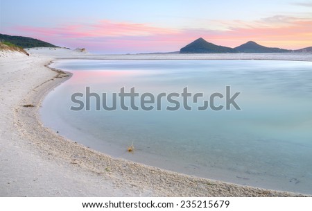 The views south east across Winda Woppa Lagoon at sunset.   The mountains of Mt Tomaree and Stephens Peak across the sea in the far distance