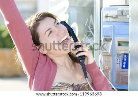 A happy woman talking at a land-line phone