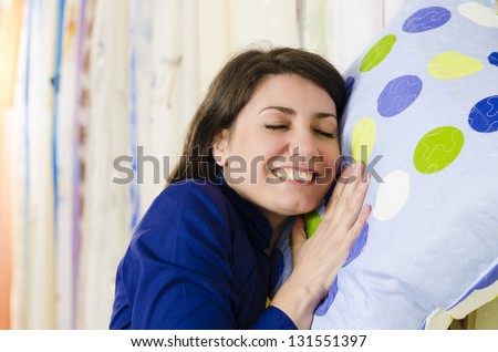 Satisfied Client in a textiles shop holding a pillow
