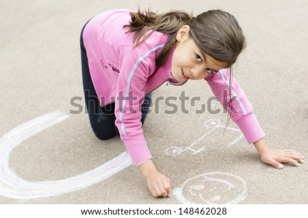 Happy Girl with her drawing on sidewalk