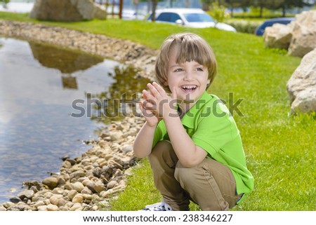Beautiful boy throwing stones into the water
