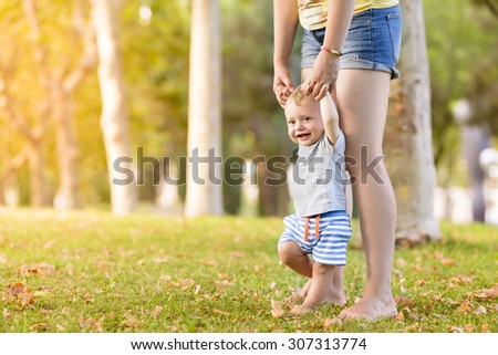 Happy Child Making First Steps in a sunny afternoon