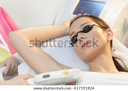 Beautiful woman getting laser hair removal at beauty salon