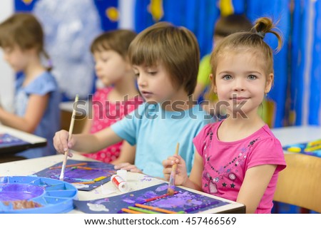 Cute kids doing their craft, painting at kindergarten