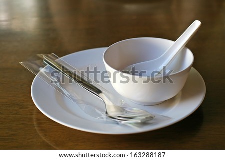 simple eating set contain with white dish, spoon, fork and soup bowl
