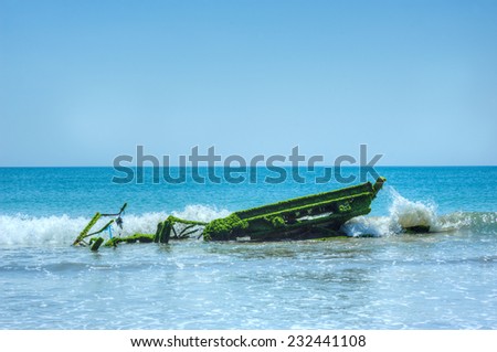 Boat covered by moss on ocean hit by small waves