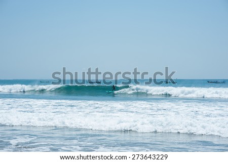 Silhouette of a man surf at Kuta Beach, Bali, Indonesia