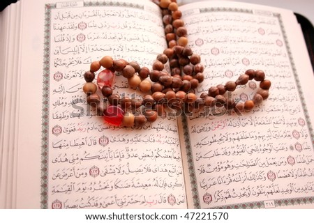A page from the Koran and prayer beads.