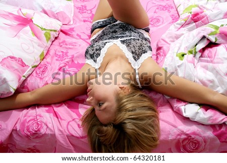 Sexy girl lying on a pink bed.