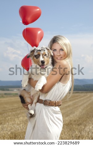 Beautiful, blonde young woman with cowboy hat and cute dog