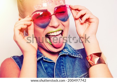 Hipster girl in glasses smiling on isolated background in studio