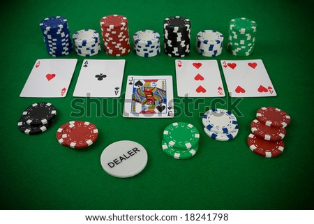 Poker set with chips and cards on the green table - dealer chip.