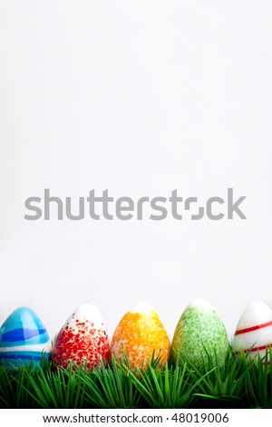 Easter eggs in green grass isolated on white background