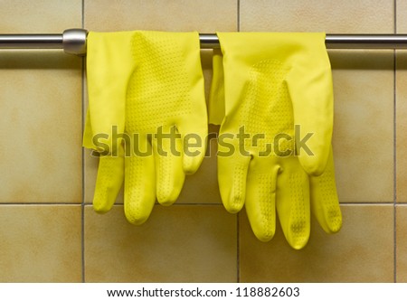 Yellow Rubber Gloves Against Kitchen\'s Wall