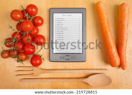 List of Recipes on a Tablet among Tomatoes and Carrots