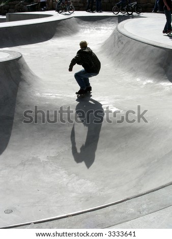 Skate boarder traversing the bowl by himself