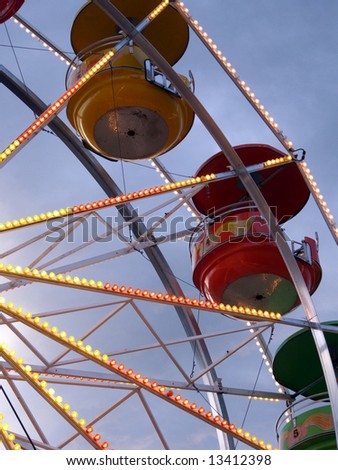 Carnival ferris wheel turning in the evening sky